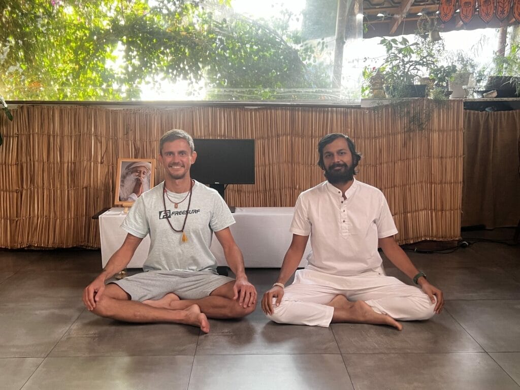 Two men sitting on the floor in a yoga pose.