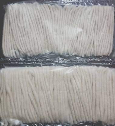 Two packs of uncooked, vacuum-sealed noodles are placed side by side on a dark surface.