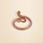 A copper snake-shaped ring on a light beige background.