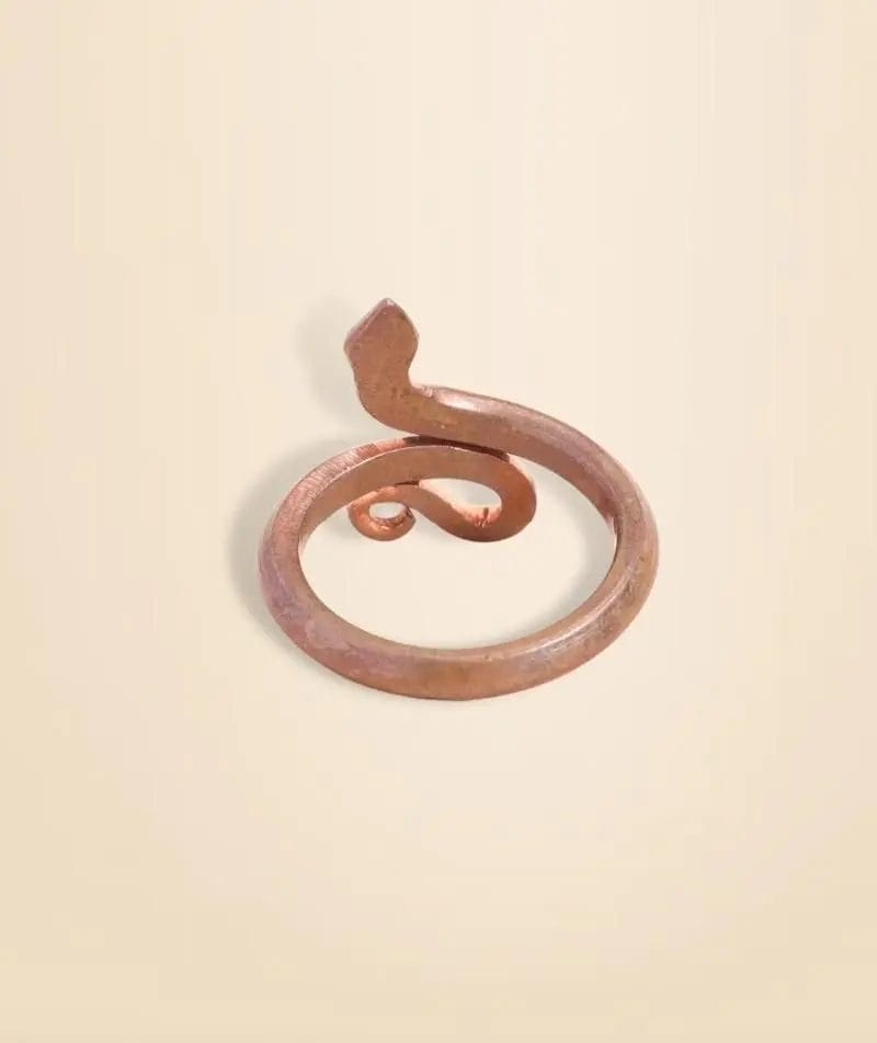 A copper snake-shaped ring on a light beige background.